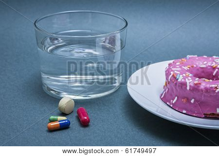 Various Medicines To Combat Diabetes Along With A Sweet Cake And Glass Water