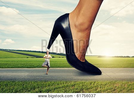 small calm woman under big female heel