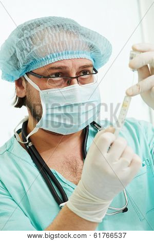 anaesthesiologist doctor in uniform preparing narcosis anaesthesia during heart transplantation operation at cardiac surgery clinic