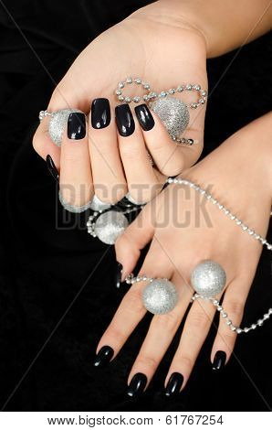 Close up on beautiful female hand with black manicure.