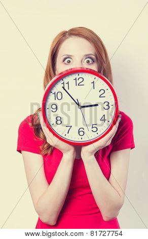 Surprised Redhead Girl With Huge Alarm Clock On Light Background.