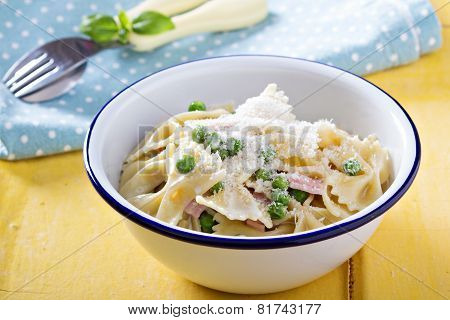 Bow ties pasta with ham and green peas