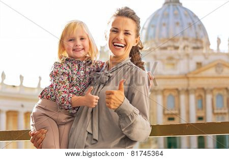 Portrait Of Happy Mother And Baby Girl On Piazza San Pietro In Vatican City State Showing Thumbs Up