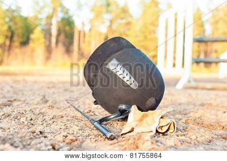 Equestrian Helmet Gloves And Whip Forgotten On The Ground