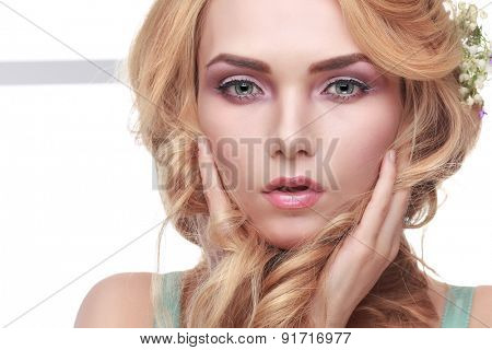 Beautiful girl, isolated on a light - grey background with varicoloured flowers in hairs, emotions, cosmetics