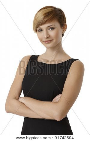 Portrait of confident young woman in black dress with arms crossed, isolated on white background