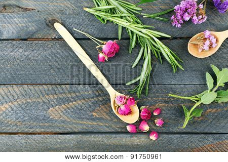 Green herbs and leaves on wooden  table, top view
