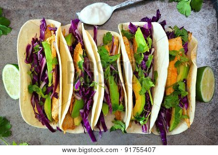 Fish tacos with red cabbage lime slaw on rustic tray
