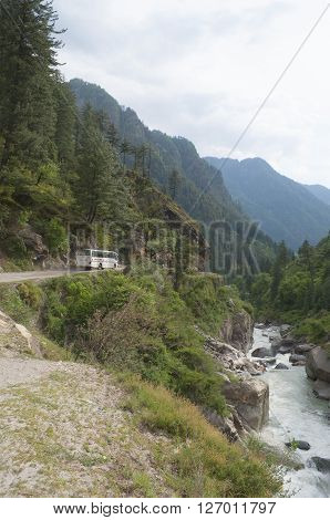 HIMACHAL PRADESH, INDIA - MAY 13, 2011: The bus goes on the route: Bhuntar - Manikaran on the mountain road above the river Parvati cloudy morning