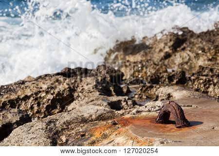 Waves smashing on a hook in a rocky sunny beach