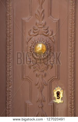 A wood brown door with gold knob and keylock