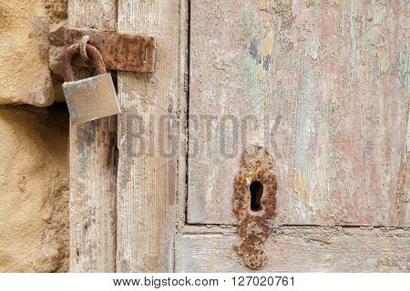 Ancient wood door with rusty lock and keyhole