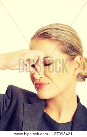 Woman pinching nose because of smell