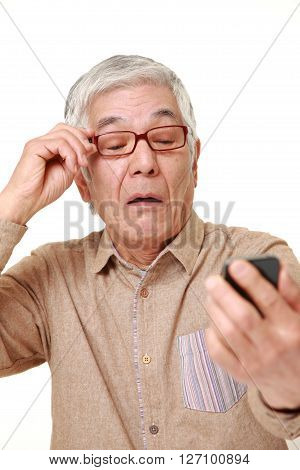 senior Japanese man with presbyopia on white background