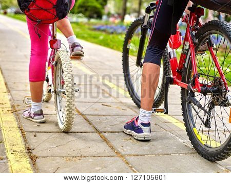 Bikes bicyclist girl. Children feet and bicycle wheel. Low section. 