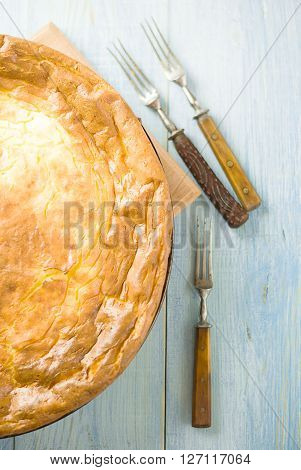 Cheese cake and three forks on over blue