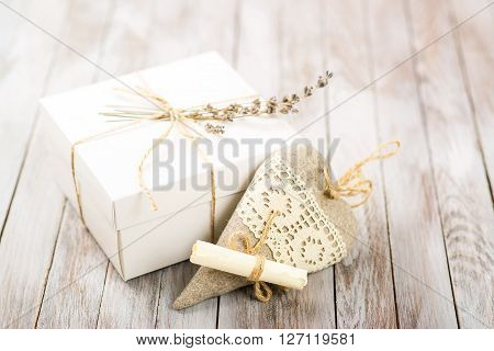 White gift box with rustic twine and a sprig of a lavender with hand