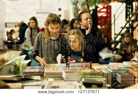 KYIV, UKRAINE - APR 21, 2016: Unidentified girls reading books at children booth of the 6th Festival BOOK ARSENAL on April 21, 2016. Guests of the fair were writers Lars Svendsen Vigdis Hjorth Etgar Keret