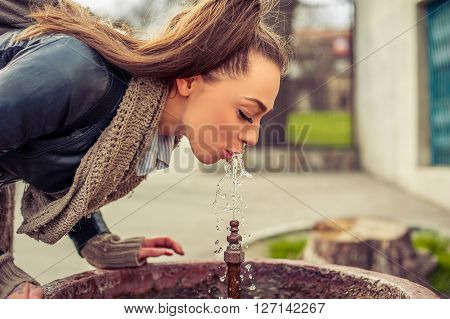 Woman drinking water from fountain. Young Woman drinking from a fresh water drink fountain
** Note: Visible grain at 100%, best at smaller sizes