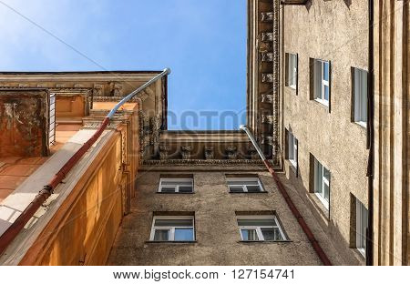 The old residential building view from below on blue sky background