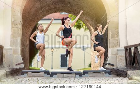 smiling women stepping training on stepper outdoor
