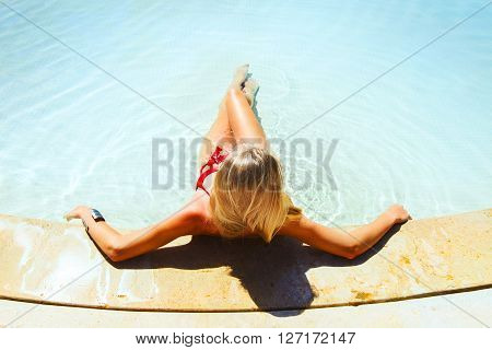 Pretty blond woman enjoying a swimming pool