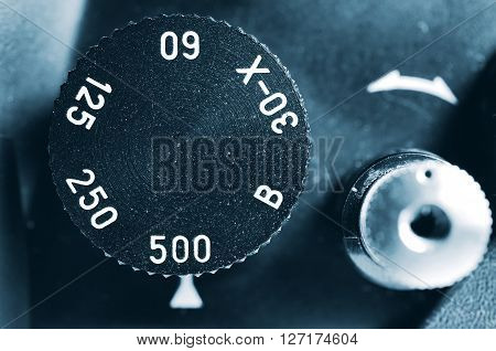 Fragment of old film camera. Top view dial of exposure and shutter button. Close up view. Macro. Selective focu. sVintage photo. Toning.