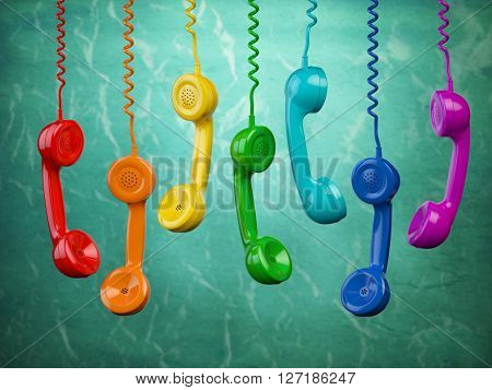Telehone receivers of different colors hanging on the green background. Communication concept. 3d illustration