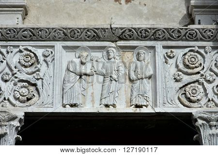 Medieval marble relief from San Pietro Somaldi Church portal with the delivery of the keys made by artist Guido Bigarelli da Como in 1238 in the historical center of Lucca