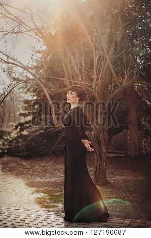 Beautiful young woman in fashion clothes in spring garden