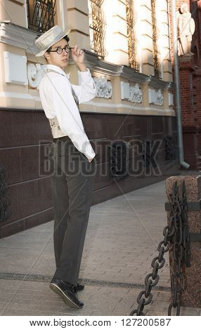 A Young Man In Fashionable Clothes Strolls On City Street