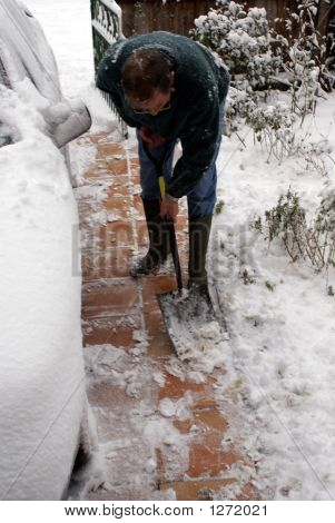 Homem limpando a neve do caminho.