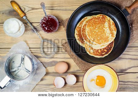 Bake Pancake. The top view of the vintage whisk mug-sieve strawberry jam and other ingredients