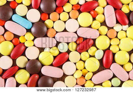 Heap of colorful medical pills capsules or supplements for therapy as background concept of treatment and health care