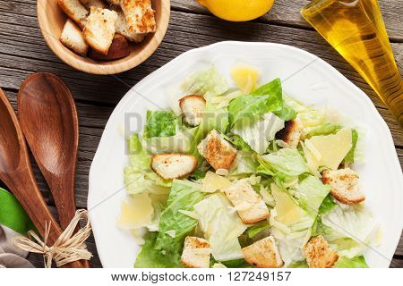 Fresh healthy caesar salad on wooden table. Top view