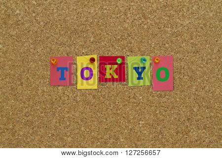 Tokyo written on colorful notes pinned on cork board.