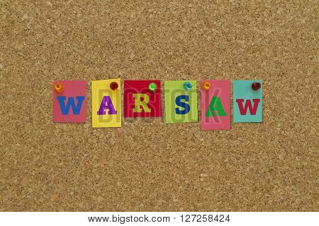 Warsaw word written on colorful notes pinned on cork board.