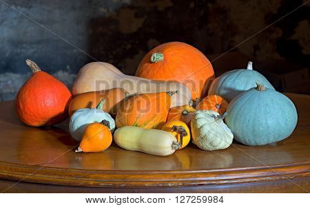 a few squashes pattypanes melones and courgettes on the old cherry desk with dark background