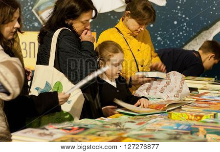 KYIV, UKRAINE - APR 21, 2016: Unidentified girl with mother watching new books of the 6th Festival BOOK ARSENAL on April 21, 2016. Guests of the fair were writers Lars Svendsen Vigdis Hjorth Etgar Keret