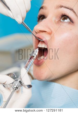 The reception was at the female dentist. Doctor examines the oral cavity on tooth decay. Caries protection. doctor puts the patient an anesthetic injection. close-up of the patient's mouth and squirt.