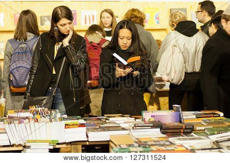 KYIV, UKRAINE - APR 21: Cute women reading new books in crowd of readers of the 6th Festival BOOK ARSENAL on April 21, 2016. Guests of the fair were writers Lars Svendsen Vigdis Hjorth Etgar Keret