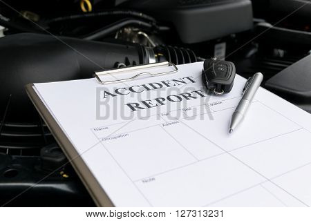 Mechanic Inspecting damage car and filling in accident report form