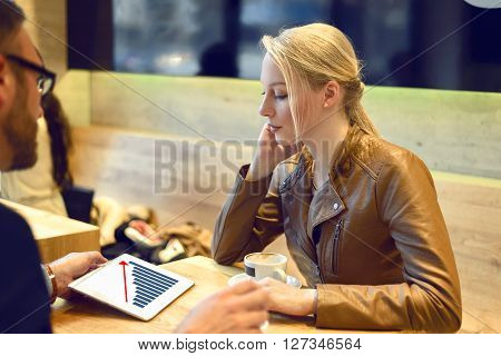 Businessman Showing Woman A Chart On Tablet