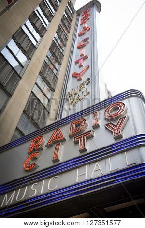 NEW YORK - 27 MAR 2016: Low angle view of the iconic Radio City Music Hall neon sign above the entrance in Manhattan on March 27, 2016. The theater hosts the Christmas Spectacular with the Rockettes.