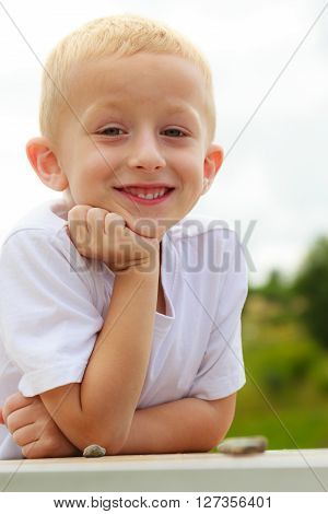Pensive boy child thinking and daydreaming. Thoughtful kid leaning on his hand looking forward. Imagination.