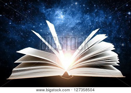 Opened magic book with sun and galaxy. Elements of this image furnished by NASA.
