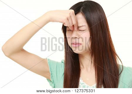 young Japanese woman suffers from Asthenopia on white background