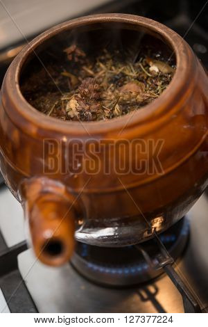 decocting medicinal herbs with enamel pot on gas burner