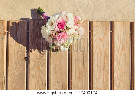 Bride's Pink and White Bouquet Laying on Pier. Wedding in Tropical Country Idea