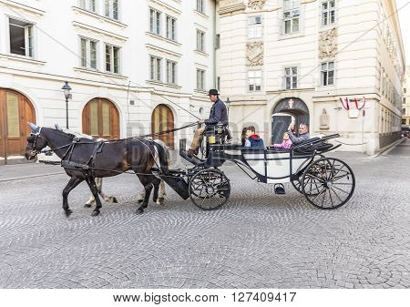 Tourists Enjoy Horse-drawn Carriage Or Fiaker